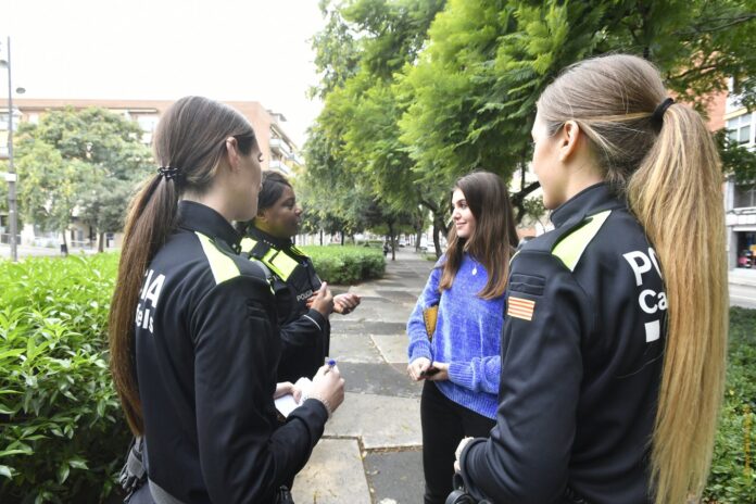 Tres policías de Castelldefels hablan con una joven en la vía pública. Imagen de archivo de 2020 (Ayuntamiento de Castelldefels)