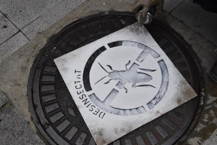 Un operario pinta una señal de 'desinfectado' en el alcantarillado (Ayuntamiento de Castelldefels)