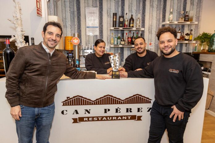 Manu Reyes, alcalde de Castelldefels, junto a Jefferson, propietario de Can Pérez, posan con el galardón Tenedor de Oro 2025 en el interior del restaurante. Foto: La Voz.